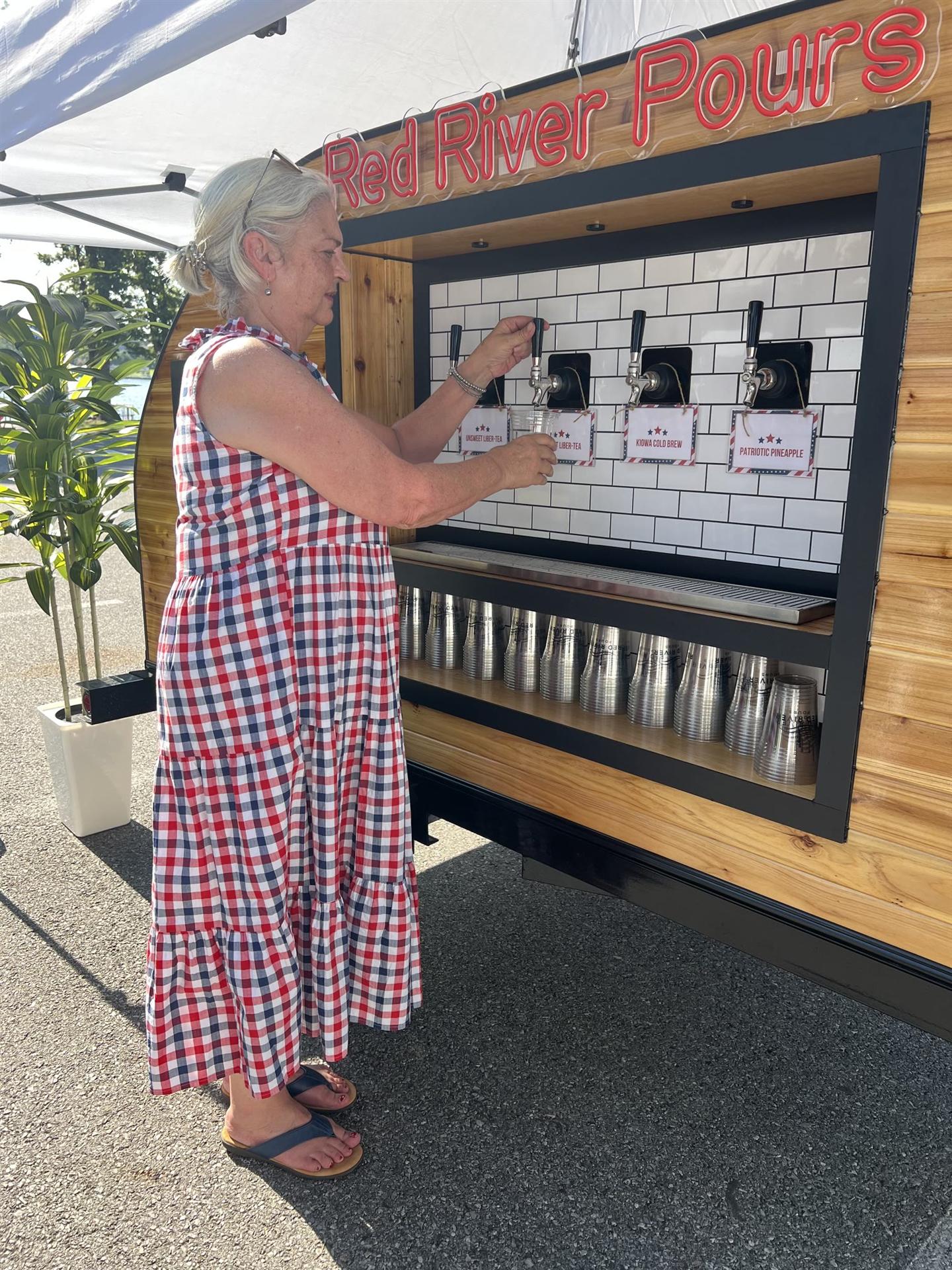 A guest choosing a drink at the Red River Pours taps
