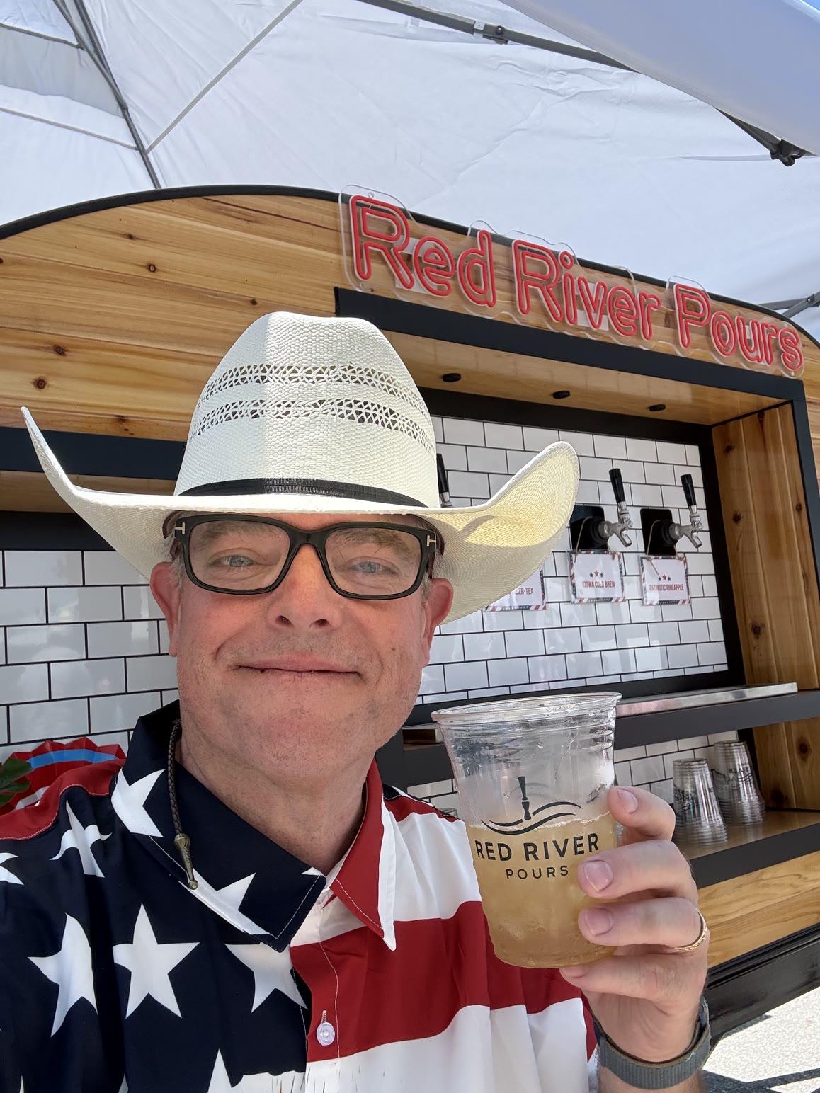 The Red River Pours owner raising a cheers with a branded cup